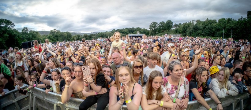 Vast audience at Replay Festival enjoying live music and outdoor entertainment in scenic surroundings.